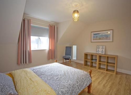 1 dormitorio con cama, escritorio y ventana en Rosslare Strand Holiday Home en Rosslare