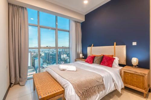 a bedroom with a large bed with a large window at SkyNest by Merlion - Urban luxury apartment in Nairobi