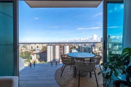 a balcony with a table and chairs and a view of a city at SkyNest by Merlion - 14th Floor - Urban Luxury - Self Check-in in Nairobi