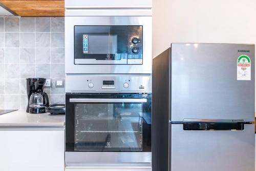 a stainless steel oven with a microwave above it at SkyNest by Merlion - 14th Floor - Urban Luxury - Self Check-in in Nairobi