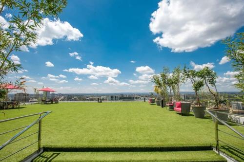 a large green field with trees and a blue sky at SkyNest by Merlion - 14th Floor - Urban Luxury - Self Check-in in Nairobi