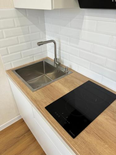 a kitchen counter with a stainless steel sink at Люкс Апартаменты White Pearl на Подолье in Vinnytsya
