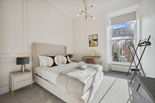a white bedroom with a bed and a window at (G1) Elegant 2 bed Blythswood Apartment in Glasgow