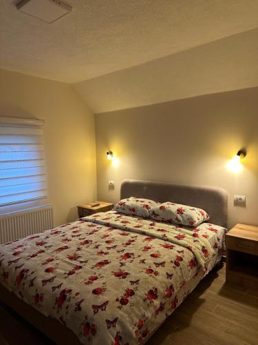 a bedroom with a bed with a floral bedspread at Apartman Pogled Arilje in Arilje