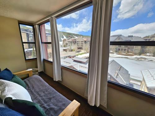 a bedroom with a large window with a view at Village square large 1 bedroom. Center Village Copper Mountain Hot tub, Parking, walk to slopes in Copper Mountain