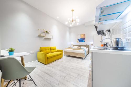 uma cozinha e sala de estar com uma cadeira amarela e uma cama em JS Modern Downtown Studios-Self Check-in em Budapeste