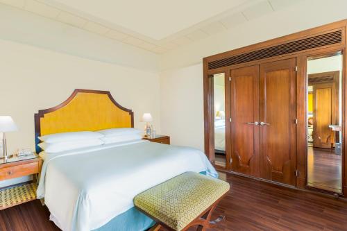 a bedroom with a large white bed and a chair at Hyderabad Marriott Hotel & Convention Centre in Hyderabad