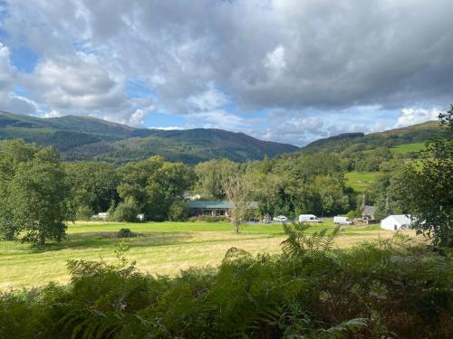 a view of a field with mountains in the background at MotoCamp Wales in Dolgellau