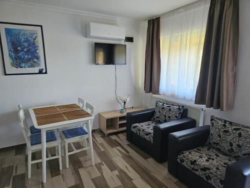 a living room with a couch and a table and chairs at Németh Apartmanok in Zalakaros