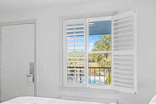 a bedroom with a window with a view of a pool at Charleston Creekside Inn in Charleston