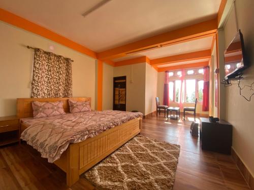 - une chambre avec un lit, une table et des chaises dans l'établissement Taktserholidays, à Tawang