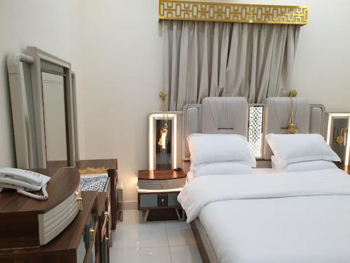 a bedroom with two beds and a mirror in it at نفداك للشقق الفندقية المفروشة in Khamis Mushayt