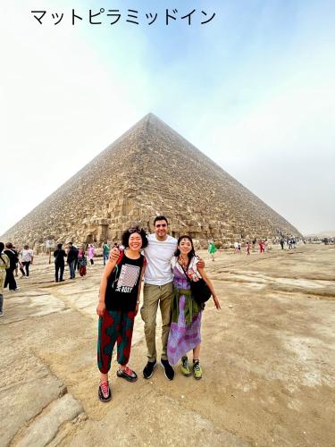 three people standing in front of a pyramid at Matto Pyramids Inn in Cairo