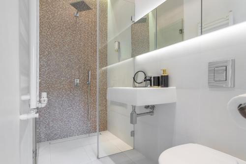 a white bathroom with a sink and a shower at Golden Apartments Warsaw - Top Location - Krakowskie in Warsaw