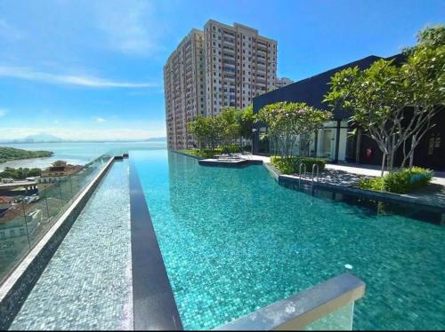 a infinity pool with a view of the water at New Brand KTV SET, Netflix, 3 Queen Bed High Floor in Jelutong