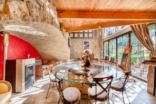 une salle à manger avec une table et des chaises en verre dans l'établissement Mas Titourin - Moulin du 18ème entièrement rénové, à Ansouis