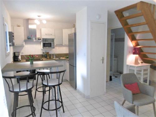 une cuisine avec un comptoir et des tabourets dans l'établissement Maison 3 pièces 4 personnes - Morgane, à Saint-Gildas-de-Rhuys