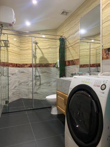 a washing machine in a bathroom with a shower at Panaroma Apartment Đà Lạt in Da Lat