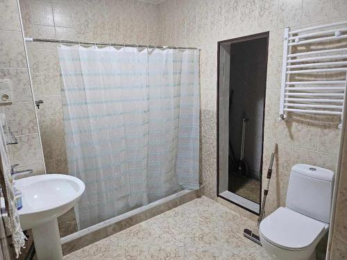 a bathroom with a shower and a toilet and a sink at RUSO'S APARTMENT in Kobuleti