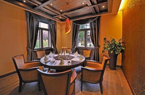 a dining room with a table and chairs and windows at Hotel Zochova Chata - Adult friendly in Modra