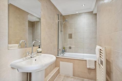 a bathroom with a sink and a bath tub at (G2) Central 1 Bed Blythswood Flat in Glasgow