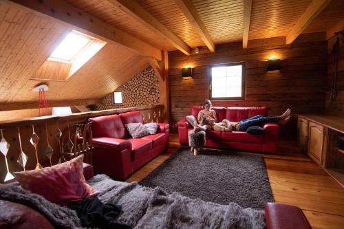a woman sitting on a couch in a room with a dog at La Ferme du Douanier & Spa 5 étoiles ALL INCLUSIVE in Ventron