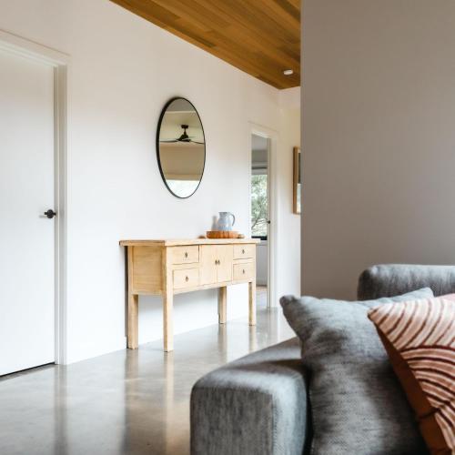 a living room with a table and a mirror at Naturally Shoreham in Shoreham