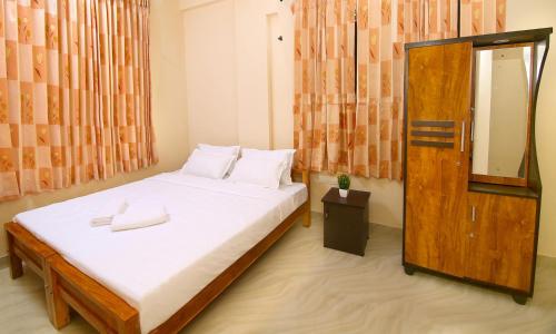 a bedroom with a large bed with a mirror at LOYAL RESIDENCY in Sultan Bathery