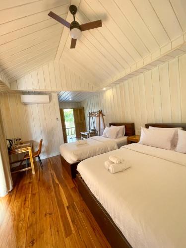 a bedroom with two beds and a ceiling fan at Nongkhiaw The Float House in Nongkhiaw