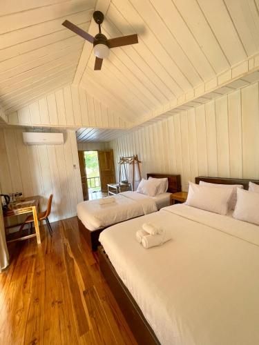 a bedroom with two beds and a ceiling fan at Nongkhiaw The Float House in Nongkhiaw