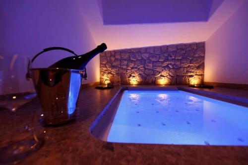 a swimming pool in a room with a bottle of champagne at Mountain Chalet Ghilga in Ortisei