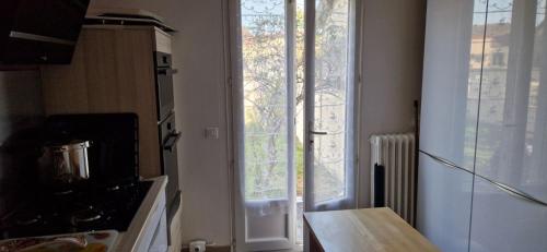 een keuken met een fornuis en een raam bij Maison spéciale JO in Villepinte