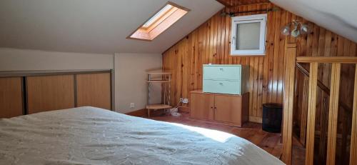 een slaapkamer met een bed en een dakraam bij Maison spéciale JO in Villepinte