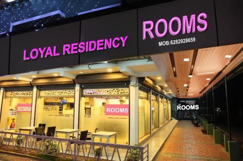 a building with a row of tables and neon signs at LOYAL RESIDENCY in Sultan Bathery