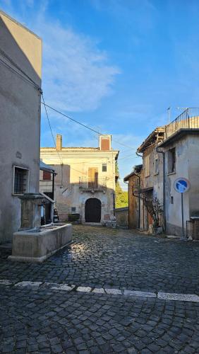 a cobblestone street in an old town with a building at La Locanda Del Castello in Ocre