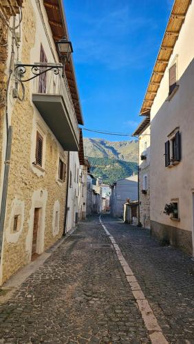 an empty cobblestone street in a town with buildings at La Locanda Del Castello in Ocre