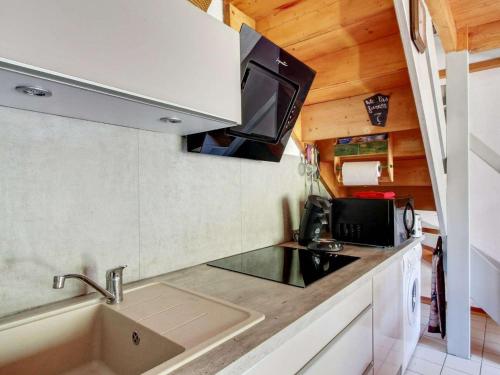 eine kleine Küche mit einer Spüle und einer Mikrowelle in der Unterkunft Appartement Viey, 3 pièces, 7 personnes - FR-1-402-120 in Viey