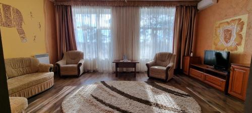 a living room with a couch and chairs and a tv at Готельно-Ресторанний Комплекс Три Бобри in Litowiż
