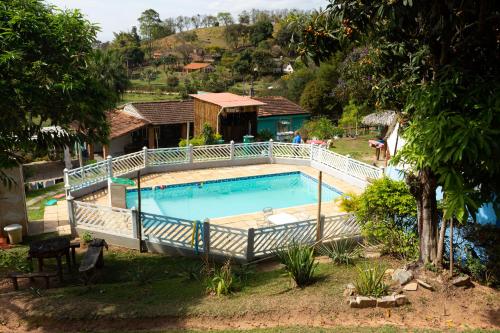 a large swimming pool with a fence around it at Pousada & Camping Recanto dos Anjos Azuis in Paty do Alferes