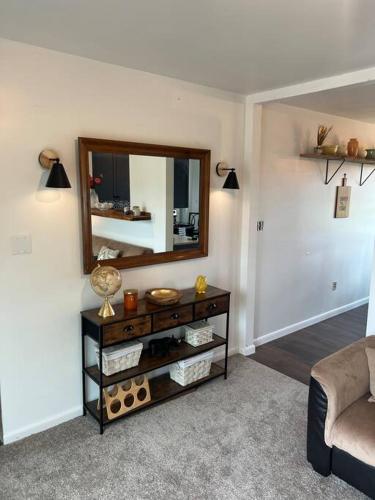 a living room with a table with a mirror at Lake View Retreat in Cambridge