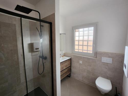 a bathroom with a shower and a toilet and a sink at Villa Rose in Le Muy