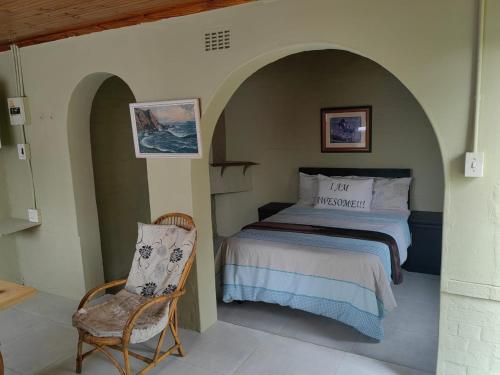 1 dormitorio con 1 cama y 1 silla en Fairfield Guest House, en Pietermaritzburg