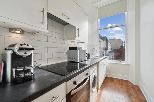 a kitchen with white walls and a window at (G3) Grand 2 bed Blythswood Apartment in Glasgow