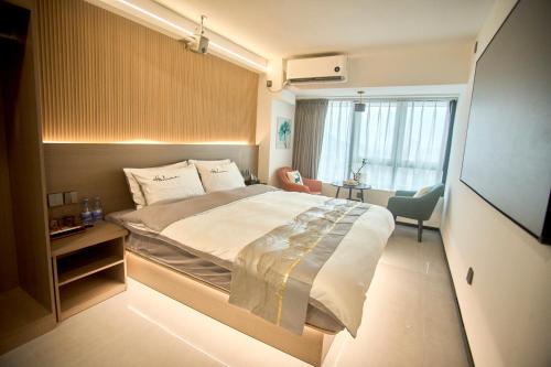 um quarto com uma cama grande e uma janela em South Wind Blowing Dreams B&B - Xiamen North Railway Station em Xiamen