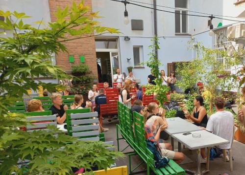 a group of people sitting at tables in a garden at Hostel Florenc in Prague