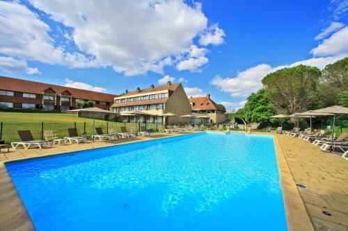 una gran piscina con sillas y un edificio en Hôtel Restaurant du Château, en Rocamadour