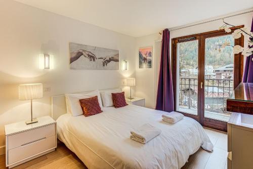 1 dormitorio con cama blanca y ventana en Apartment Alpes IV - Alpes Travel - Central Chamonix (sleeps 4), en Chamonix-Mont-Blanc