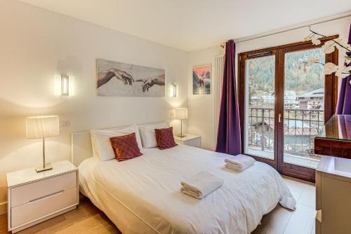 une chambre avec un lit blanc et une fenêtre dans l'établissement Apartment Alpes IV - Alpes Travel - Central Chamonix (sleeps 4), à Chamonix-Mont-Blanc