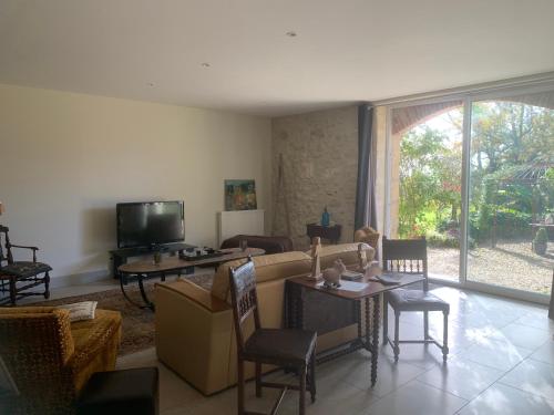 un salon avec un canapé et une télévision dans l'établissement La Dépendance de Bazin, à Marmande