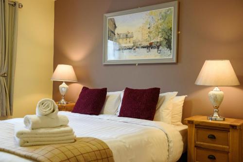 een slaapkamer met een wit bed met 2 lampen en een stoel bij Waterfront Self Catering Houses in Carrick on Shannon